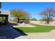 Expansive backyard with artificial turf, desert landscaping, and a patio with a table and chairs at 7910 E Snowdon Cir, Mesa, AZ 85207