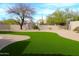 Beautiful backyard featuring lush artificial turf, desert landscaping, and a rock perimeter at 7910 E Snowdon Cir, Mesa, AZ 85207