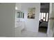 Bright bathroom with single sink vanity and neutral countertops with a peek into the Primary bedroom at 7910 E Snowdon Cir, Mesa, AZ 85207