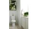 Cozy bathroom with a tiled floor, a white toilet, and a decorative plant above the sink at 7910 E Snowdon Cir, Mesa, AZ 85207