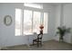 Sunlit room featuring a writing desk, a decorative lamp, and neutral carpet at 7910 E Snowdon Cir, Mesa, AZ 85207