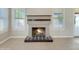 Close-up of the living room fireplace with decorative tile and a wooden mantle, flanked by shuttered windows at 8661 N 108Th Ln, Peoria, AZ 85345