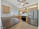 Kitchen view features stainless steel appliances and light wood cabinets, plus breakfast bar at 8661 N 108Th Ln, Peoria, AZ 85345