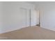 A bright bedroom featuring neutral carpet, white walls and sliding door closet at 9121 W Alvarado St, Phoenix, AZ 85037