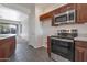 Modern kitchen with stainless steel appliances, granite countertops, and dark wood cabinets at 9121 W Alvarado St, Phoenix, AZ 85037