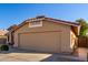 A tan two-car garage with a tile roof and desert landscaping at 9853 W Irma Ln, Peoria, AZ 85382