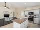 Open-concept kitchen with a central island, flowing seamlessly into the living room for a modern living experience at 9853 W Irma Ln, Peoria, AZ 85382