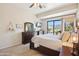 Bright bedroom with wood-look flooring, a dresser with a mirror, and sliding doors to backyard views at 9870 E Little Nugget Way, Gold Canyon, AZ 85118