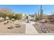 Southwestern home with desert landscaping, cacti, mature trees, and a decorative water feature at 9870 E Little Nugget Way, Gold Canyon, AZ 85118