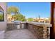 Covered outdoor kitchen with a built-in grill and bar seating area, perfect for entertaining at 9870 E Little Nugget Way, Gold Canyon, AZ 85118