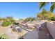 Backyard with a built-in fire pit, steps to an upper terrace, desert landscaping, and privacy wall at 9870 E Little Nugget Way, Gold Canyon, AZ 85118