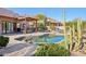 Backyard pool and patio with a covered outdoor kitchen and desert landscaping at 9870 E Little Nugget Way, Gold Canyon, AZ 85118