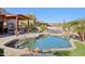 Backyard pool area with desert landscaping and a covered outdoor kitchen at 9870 E Little Nugget Way, Gold Canyon, AZ 85118