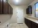 Laundry room with tile floors and cabinets above and below the countertop at 10731 W Wikieup Ln, Peoria, AZ 85373