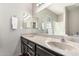 Double sink bathroom featuring a large vanity, framed mirror, neutral walls, and decorative accents at 11026 E Nopal Ave, Mesa, AZ 85209