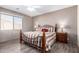 A cozy bedroom featuring wood floors, neutral walls, ceiling fan, and a queen-size bed with decorative pillows at 11026 E Nopal Ave, Mesa, AZ 85209