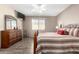 Bedroom featuring wood floors, large window, dresser and television at 11026 E Nopal Ave, Mesa, AZ 85209