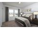 Bright bedroom featuring three windows, a queen-size bed, and modern decor at 11675 N Siders Ln, Maricopa, AZ 85139