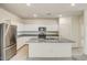 A kitchen with stainless steel refrigerator, island, granite countertops and white cabinets at 11675 N Siders Ln, Maricopa, AZ 85139