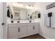 Modern bathroom showcasing a double sink vanity with white countertops, sleek black fixtures, and decorative wall art at 13224 W Crimson Ter, Peoria, AZ 85383