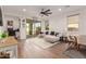 Bright living room with tile flooring, a ceiling fan, and sliding glass doors to the backyard at 13224 W Crimson Ter, Peoria, AZ 85383