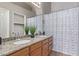 Bathroom featuring double sinks, granite countertops, and a shower with a patterned curtain at 13425 N 92Nd Pl, Scottsdale, AZ 85260