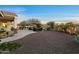 Lush backyard featuring an outdoor kitchen, multiple seating areas, and verdant landscaping at 13583 S 177Th Ln, Goodyear, AZ 85338