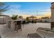 Sunset view of outdoor kitchen and built in bbq with bar top. Lounge chairs sit on the concrete patio at 13583 S 177Th Ln, Goodyear, AZ 85338