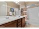 Spacious bathroom with double vanity, dark wood cabinets, and a combined shower-tub with white tile surround at 13583 S 177Th Ln, Goodyear, AZ 85338