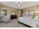 Comfortable carpeted bedroom featuring a sitting area, dresser with mirror, and a ceiling fan for added comfort at 13583 S 177Th Ln, Goodyear, AZ 85338