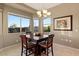 Bright dining area featuring large windows for natural light, a modern chandelier, and neutral walls at 13583 S 177Th Ln, Goodyear, AZ 85338