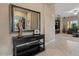 Stylish foyer with a dark wood console table, large mirror, and a view into the spacious living area at 13583 S 177Th Ln, Goodyear, AZ 85338