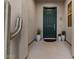 Elegant entryway with a dark green front door, potted plants, and a decorative metal cactus at 13583 S 177Th Ln, Goodyear, AZ 85338