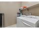 Neat laundry room with washer, dryer, storage shelf, and neutral walls at 13583 S 177Th Ln, Goodyear, AZ 85338