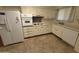 Traditional kitchen featuring white cabinets and appliances plus a light brown tile floor at 13846 N Tan Tara Dr, Sun City, AZ 85351