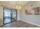 Bright dining room featuring wood floors, a modern chandelier, and sliding glass door to the patio at 13914 W Terra Vista Dr, Sun City West, AZ 85375