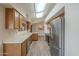 Bright kitchen with wood cabinets, white countertops, stainless steel refrigerator, and wood-look flooring at 13914 W Terra Vista Dr, Sun City West, AZ 85375