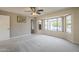 Open living room with a ceiling fan, neutral carpet, neutral paint and expansive windows at 13914 W Terra Vista Dr, Sun City West, AZ 85375