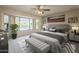 Staged main bedroom with a sitting area, plush carpet, neutral walls, ceiling fan, and ample natural light at 13914 W Terra Vista Dr, Sun City West, AZ 85375