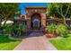 Stately brick home featuring a grand arched entryway, lush landscaping, and a beautiful brick walkway at 1440 N 40Th St # 4, Mesa, AZ 85205