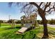 View of a neighborhood playground with a playset, swings, and mature trees on a green lawn at 1440 N 40Th St # 4, Mesa, AZ 85205