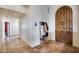 Inviting foyer featuring a statement wooden door, tile flooring, and convenient coat and shoe storage at 15101 E Aspen Dr, Fountain Hills, AZ 85268