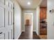 Hallway leading to a bedroom and the kitchen, showcasing hardwood floors and ample lighting at 15101 E Aspen Dr, Fountain Hills, AZ 85268