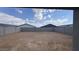 View of the spacious backyard featuring block fence, dirt, and blue skies above at 15761 W Beryl Ave, Waddell, AZ 85355