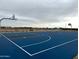 Blue community basketball court with hoops, white lines, and nearby bench for relaxation at 15761 W Beryl Ave, Waddell, AZ 85355