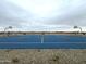 Outdoor basketball court featuring blue surface, white lines, hoops, and a stone perimeter at 15761 W Beryl Ave, Waddell, AZ 85355