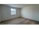 Empty bedroom with carpet flooring, a large window, and neutral colored walls at 15761 W Beryl Ave, Waddell, AZ 85355
