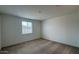 A bright, neutral-toned bedroom with plush carpeting and a window at 15761 W Beryl Ave, Waddell, AZ 85355