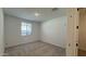 A tidy bedroom featuring carpet, white walls, a window for natural light, and an open doorway at 15761 W Beryl Ave, Waddell, AZ 85355