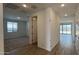 Bright hallway connects a bedroom with a large window to another room with tile flooring at 15761 W Beryl Ave, Waddell, AZ 85355